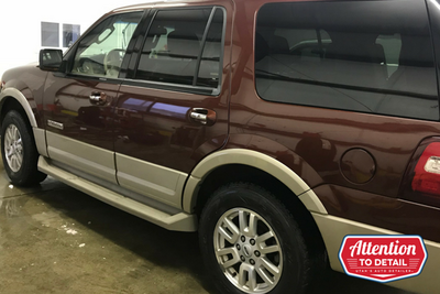 A fresh and clean suburban after a full detail shines in the fluorescent lights.